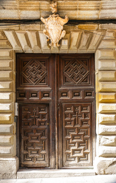 Tolède, Espagne- 6 octobre 2022. Vieille façade en pierre avec armoiries et porte vintage en bois - Photo, image