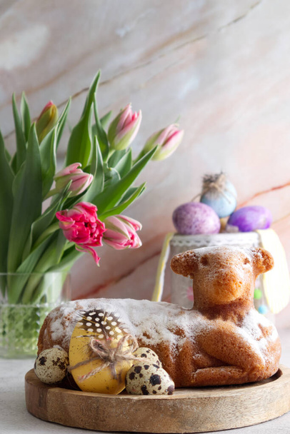 Gâteau de Pâques en forme d'agneau avec œufs de Pâques et fleurs de printemps sur la table close up - Photo, image