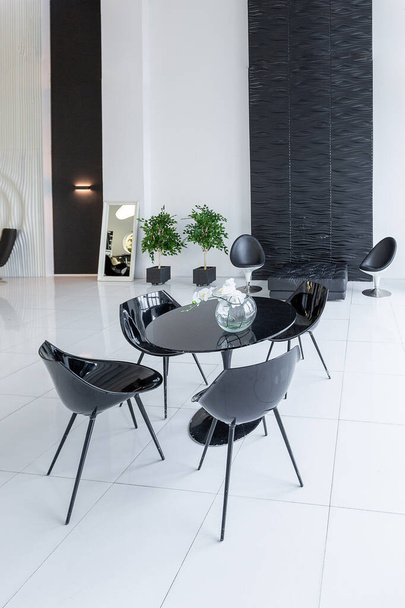 Luxurious futuristic trendy modern interior in contrasting black and white colors with interesting fashionable black furniture and decorated wall - Fotó, kép
