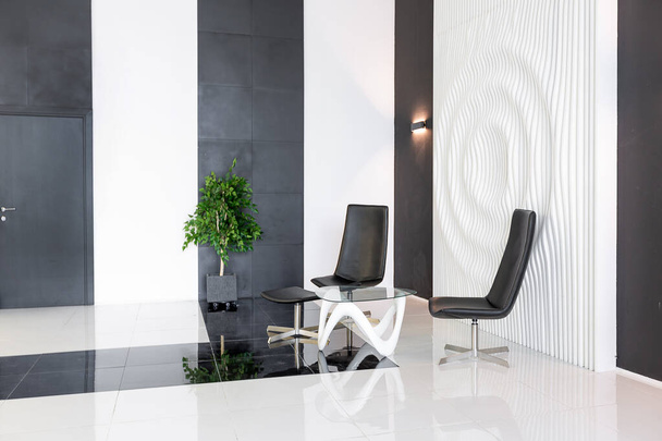 Luxurious futuristic trendy modern interior in contrasting black and white colors with interesting fashionable black furniture and decorated wall - Фото, зображення