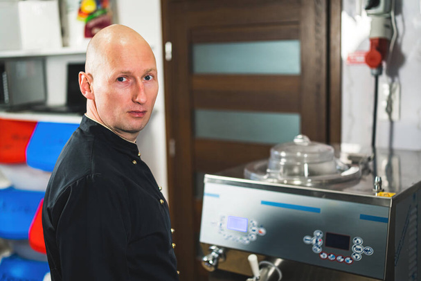 Male pastry chef working with pasteurization machine for ice cream production . High quality photo - Фото, изображение