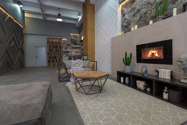 современный интерьер студии с декоративными каменными стенами в сером. Каменное дерево, плитка и световое освещение в оформлении комнаты - Фото, изображение