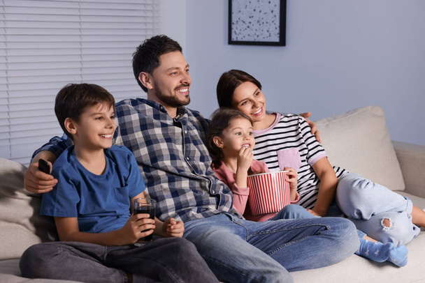 Happy family watching TV at home in evening - Foto, Imagem