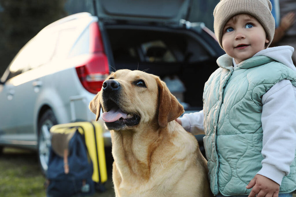 Cute kid and dog outdoors. Family traveling with pet - Photo, Image