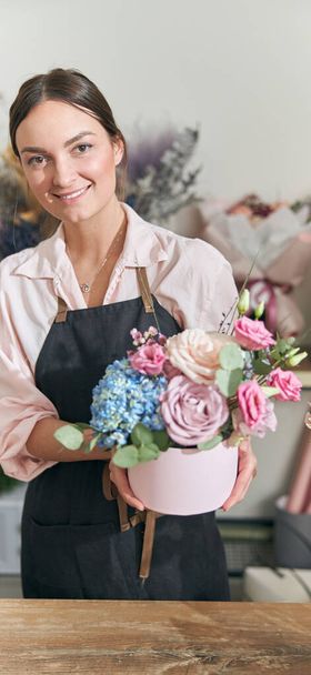 happy professional woman is working in flower shop - Фото, зображення