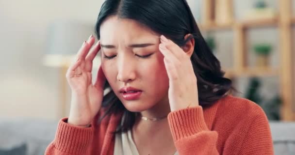 Pain, stress and woman with headache, mental health and dizzy feeling in living room, depression and problems. Asian female and migraine in lounge, tension and muscle strain with anxiety and burnout. - Footage, Video