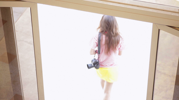 Όμορφο κορίτσι με μια φωτογραφική μηχανή που βγαίνει από το ξενοδοχείο - Πλάνα, βίντεο