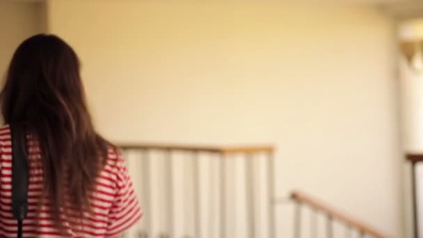 Piękna dziewczyna schodzi po schodach w holu - Materiał filmowy, wideo