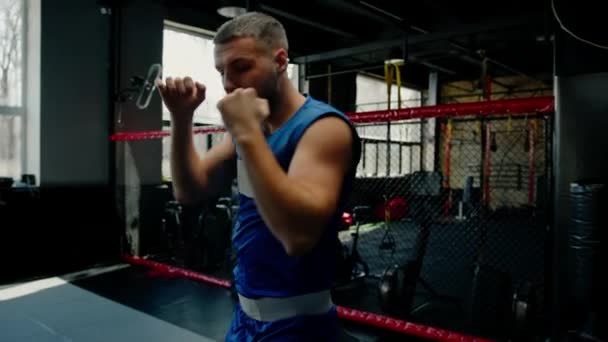 Hombre boxeador entrenamiento en forma hombre haciendo boxeo gimnasio joven haciendo calentamiento músculos de estiramiento - Imágenes, Vídeo