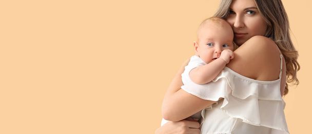 Happy moeder met schattige kleine baby op beige achtergrond met ruimte voor tekst - Foto, afbeelding