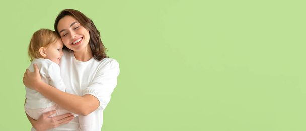 Happy woman and her little baby on green background with space for text - Photo, Image