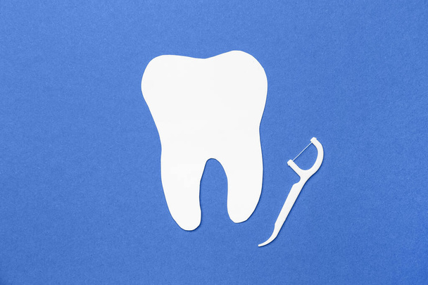 Floss toothpick and tooth model on blue background - Photo, Image