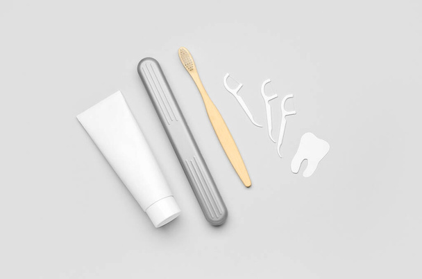 Floss palitos de dentes, tubo de pasta, escova e modelo de dente em fundo cinza - Foto, Imagem