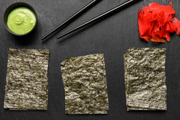 Slate board with nori sheets, ginger, wasabi and chopsticks, close seup - Фото, изображение
