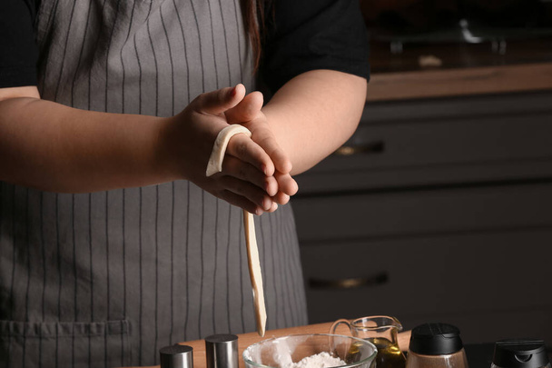 Vrouw voorbereiding Italiaanse Grissini aan tafel in de keuken, close-up - Foto, afbeelding