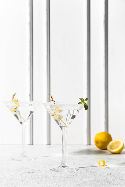Glasses of tasty martini and lemon on white table - Foto, Imagem