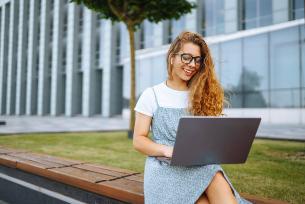 Young woman with laptop outdoor. Education online. Freelancer, Business, shopping, blogging. - Фото, изображение