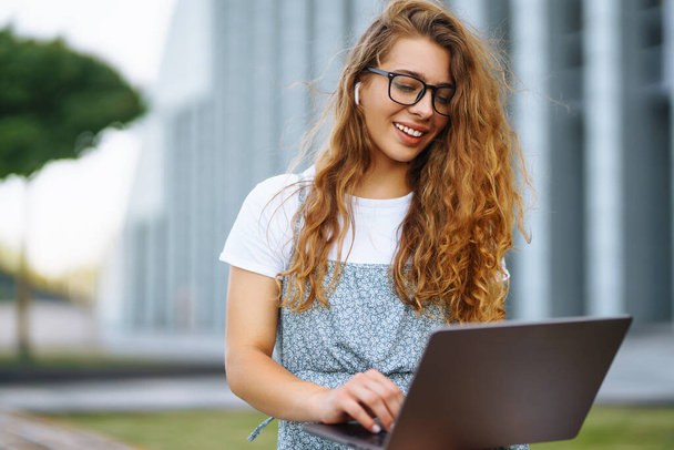 Young woman with laptop outdoor. Education online. Freelancer, Business, shopping, blogging. - Foto, imagen
