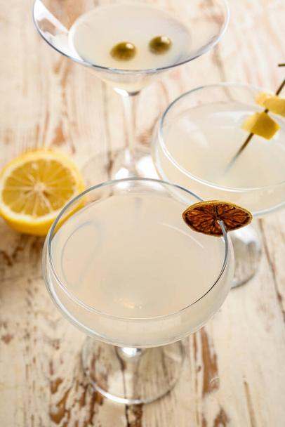 Glasses of martini with lemon on light wooden background - Photo, image