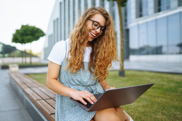 Young woman with laptop outdoor. Education online. Freelancer, Business, shopping, blogging. - Фото, изображение