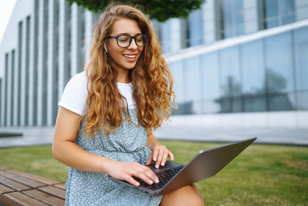 Young woman with laptop outdoor. Education online. Freelancer, Business, shopping, blogging. - Foto, afbeelding