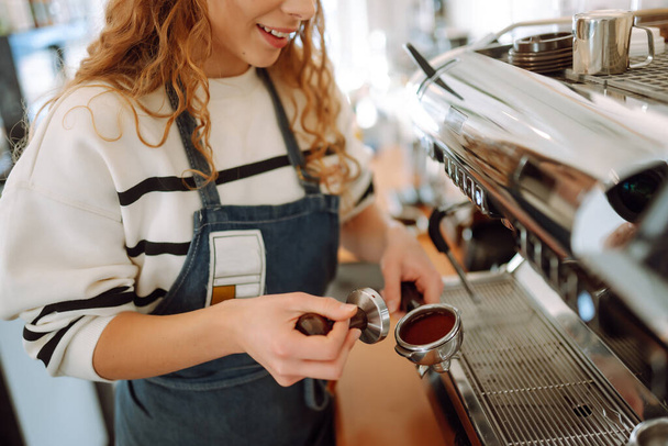 Female barista making coffee in a coffee machine. Conception of business and service. Takeaway food. - Foto, Imagem