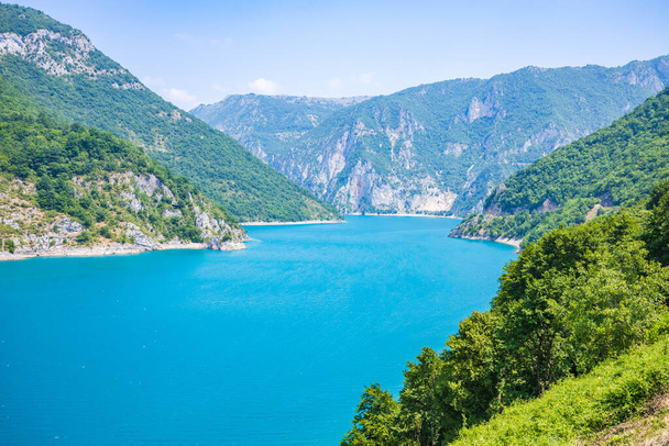 Landscape view of big lake between mountains at summer day. Travel background image with Piva lake in Montenegro - Valokuva, kuva