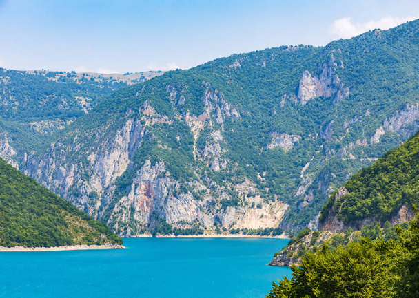 Landscape view of big lake between mountains at summer day. Travel background image with Piva lake in Montenegro - Fotografie, Obrázek