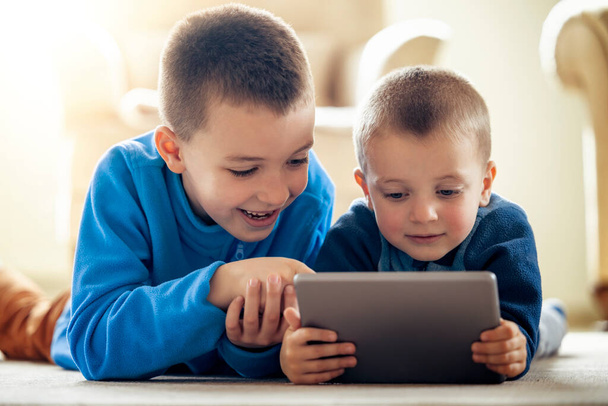 Boys playing video games on the tablet at home. - Zdjęcie, obraz