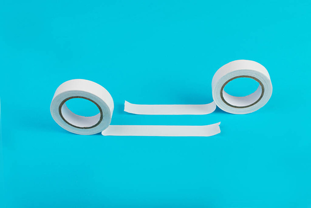 White Electrical Tape, Plastic Duct Tape Rolls, Colored Adhesive Tapes on Blue Background - Foto, imagen