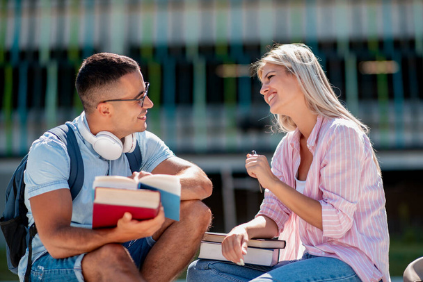 Retrato de casal ao ar livre com livros, aprendendo juntos para o exame. - Foto, Imagem