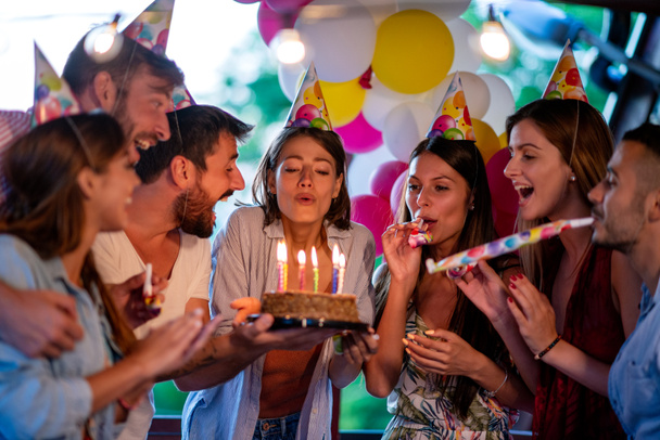 Group of friends celebrating birthday together outdoors. Concept of celebrating and happiness. - Photo, Image