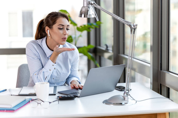 Portrait of businesswoman working on laptop in office. - 写真・画像