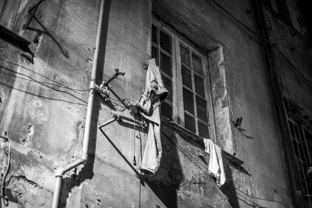 джинсы, висящие на стене дома с окном, означают поспешный и Роккамболеск отъезда - Фото, изображение