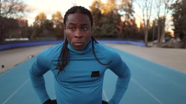 africano hombre deportista en pista de correr de pie mirando alrededor - Metraje, vídeo