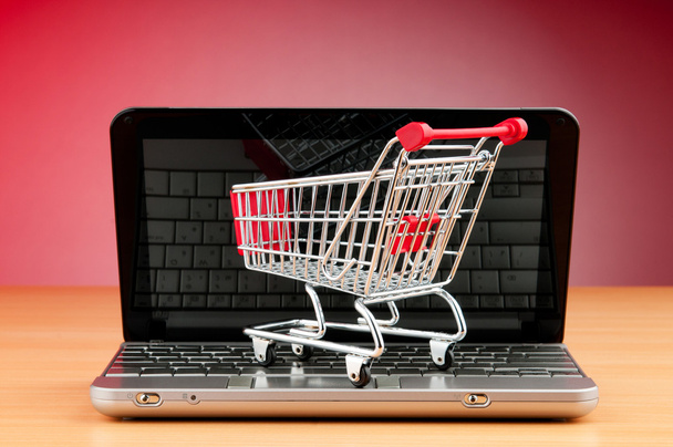 Internet online shopping concept with computer and cart - Foto, afbeelding