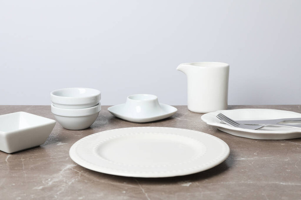 Mínimo ajuste de mesa con plato en blanco en mesa gris texturizada - Foto, imagen