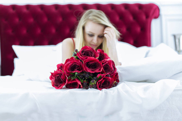Chic blonde woman in luxury white with red bedroom. Rich expensive interior. - Fotografie, Obrázek