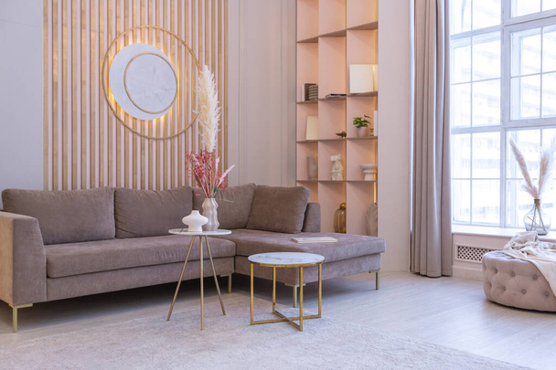 luxurious modern interior of the living room of an expensive spacious bright apartment. upholstered furniture and decorative lighting, soft pastel colors and cozy atmosphere - Zdjęcie, obraz