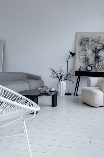 modern minimalistic interior design of light bright monochrome room with black and white furniture, clean white walls and huge windows - Foto, afbeelding
