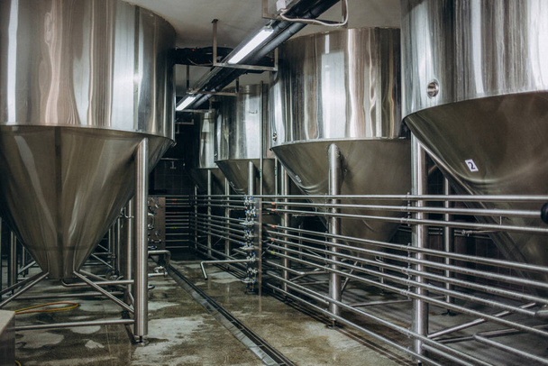 Bira fabrikasındaki tanklar. Bira tanklarında mayalanma ve bira mayalanması. Modern bira fabrikası. Depo için büyük çelik tanklar. Kamera görüntüsü baştan aşağı - Fotoğraf, Görsel