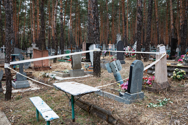 cohete sin explotar vallado por seguridad con cinta de advertencia se puede ver en el cementerio de Izyum, Kharkiv reg, Ucrania - Foto, imagen