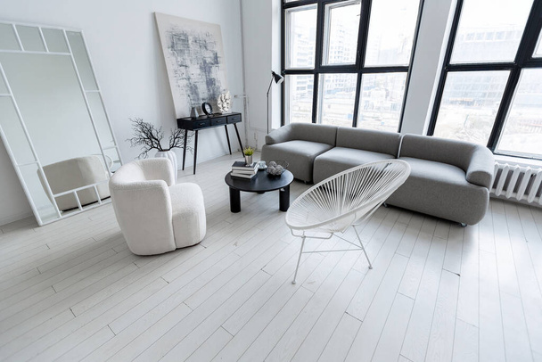 modern minimalistic interior design of light bright monochrome room with black and white furniture, clean white walls and huge windows - 写真・画像