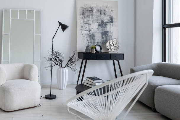 nowoczesny minimalistyczny wystrój wnętrz jasnego pokoju monochromatycznego z czarno-białymi meblami, czystymi białymi ścianami i ogromnymi oknami - Zdjęcie, obraz