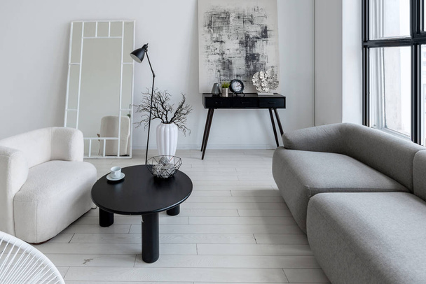 modern minimalistic interior design of light bright monochrome room with black and white furniture, clean white walls and huge windows - Foto, Imagen