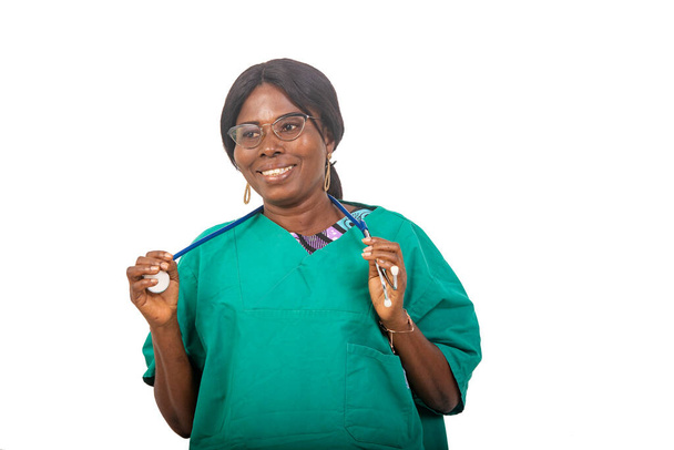 una hermosa enfermera en gafas de pie sobre fondo blanco con estetoscopio mirando a la cámara riendo. - Foto, imagen