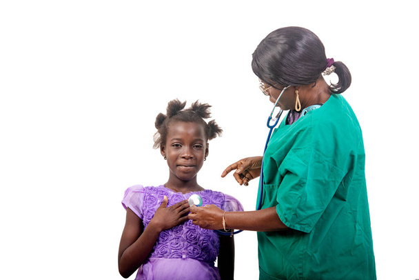 beautiful nurse in glasses standing over white background consulting female patient using stethoscope while talking. - Photo, Image