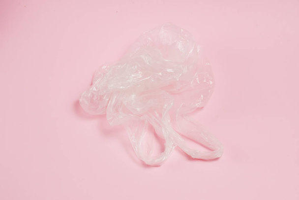 Plastiktüte auf rosa Papierhintergrund. Konzept von Earth Day, Zero Waste und Recycling. - Foto, Bild