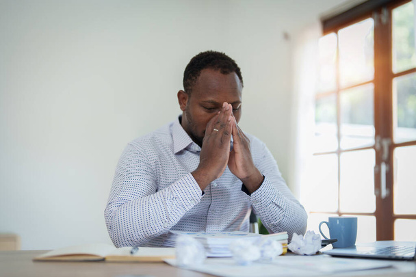 Burnout Amerikaanse Afrikaanse zakenman in stress werkt met veel papierwerk document, migraine aanval, Freelance, werk van thuis uit. - Foto, afbeelding