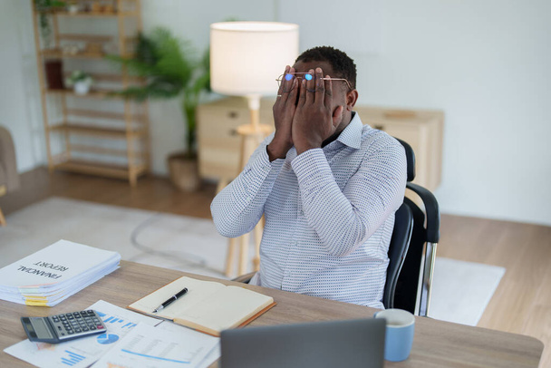 Burnout Américain homme d'affaires africain dans le stress travaille avec de nombreux documents de paperasserie, attaque de migraine, Freelance, travail de la maison. - Photo, image